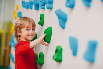 Portrait of boy standing against multi colored background