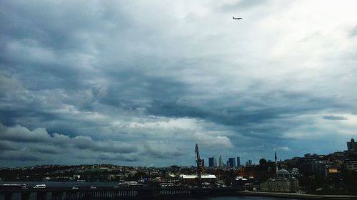 Buildings in city against storm clouds