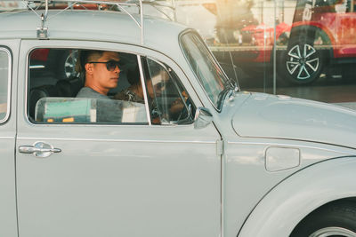 Portrait of man looking through car window