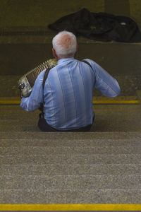 Rear view of man playing piano