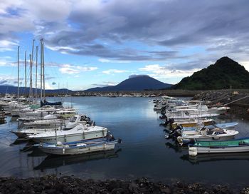 Sailboats moored on lake against sky