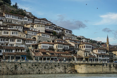 Buildings in city against cloudy sky