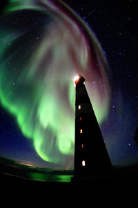 Low angle view of illuminated building against sky at night