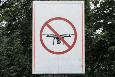 Close-up of drone forbidden sign against trees
