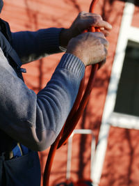 Midsection of man folding cables