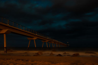 Low angle view of bridge over sea against sky during sunset