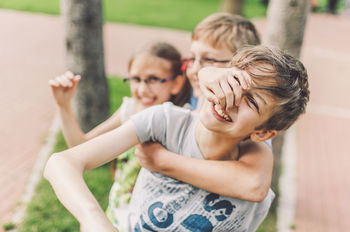 PORTRAIT OF HAPPY GIRL PLAYING WITH ARMS RAISED