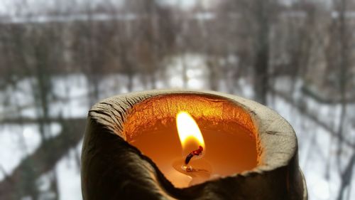 Close-up of lit candle against blurred background