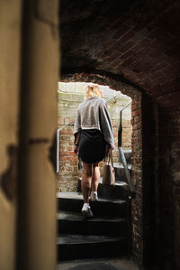 Rear view of woman walking on staircase in building