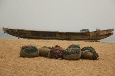 View of boats moored on beach against clear sky