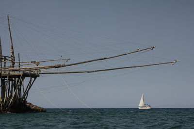 Sailboat sailing in sea against clear sky