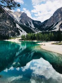 Scenic view of lake by snowcapped mountains against sky