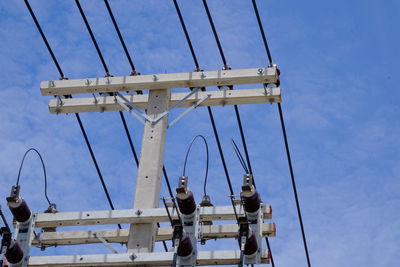 Low angle view of cranes against blue sky