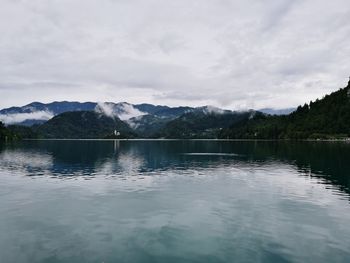 Scenic view of lake by mountains against sky