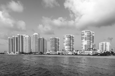 Modern buildings in sea against sky