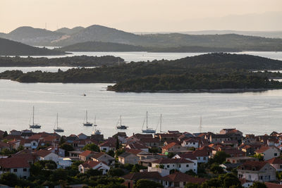 High angle view of townscape by sea against sky