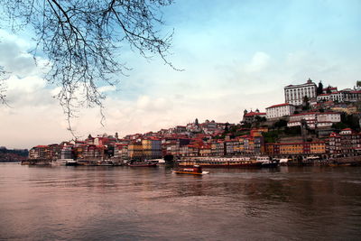 River amidst buildings in city against sky