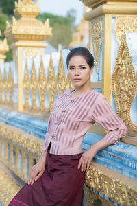 Young woman standing against built structure