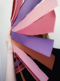 Cropped image of woman holding multi colored paper