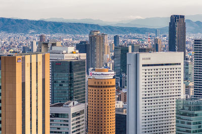 Aerial view of buildings in city against sky