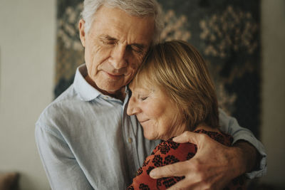 Senior couple hugging at home