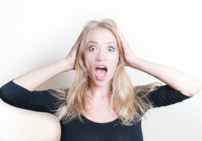 Portrait of smiling young woman against white background