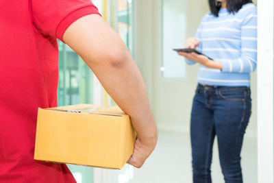 Midsection of woman holding mobile phone