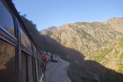 Road amidst mountains against clear sky