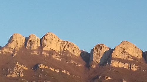 Panoramic view of rocky mountains against clear blue sky