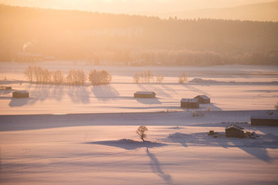 Scenic view of frozen lake against sky during sunset