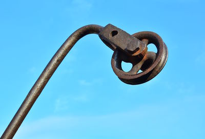 Close-up of rusty metal against blue sky