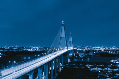 Illuminated bridge against sky at night