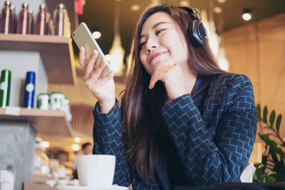 Young woman using phone on table