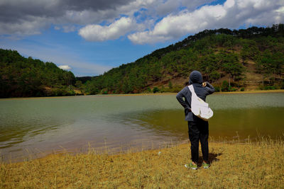 Man standing on lake against sky