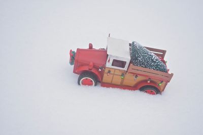 Close-up of toy car on snow against white background