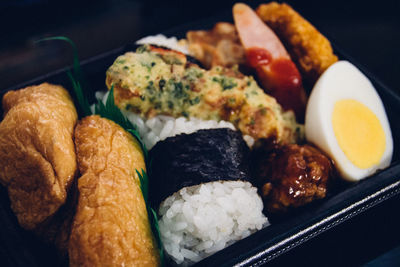 Close-up of sushi with meat and egg in container