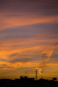 Silhouette buildings against sky during sunset