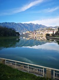 Scenic view of lake by buildings against sky