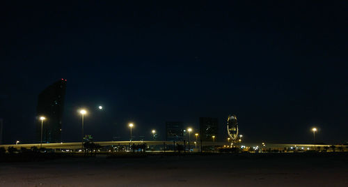 Illuminated buildings against sky at night