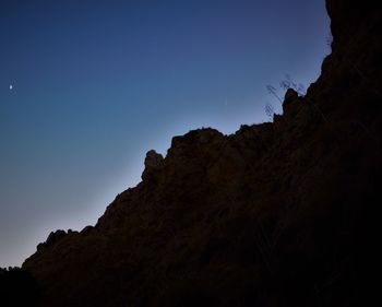 Low angle view of rock formation against clear sky at dusk