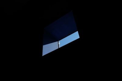 Low angle view of blue window in darkroom