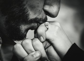 Midsection of man kissing woman fingers