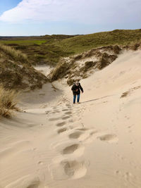 Rear view of man walking on beach