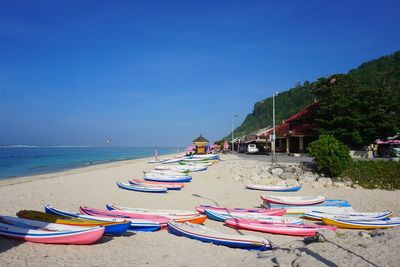 Boats on shore against calm blue sea