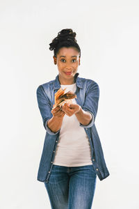 Portrait of smiling young woman standing against white background