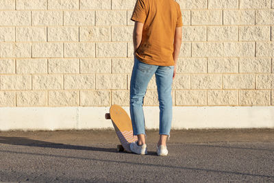 Full length of man standing against wall