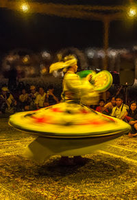 Blurred motion of people in yellow water at night