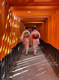 Rear view of women walking on footpath