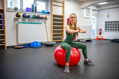 Full length of woman exercising in gym