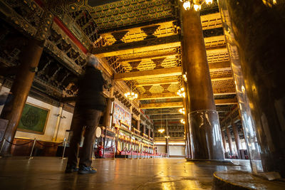 Rear view of woman walking in illuminated building